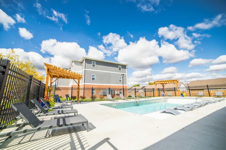 Poolside has plenty of seating area, with pergolas and wide, concrete paths.