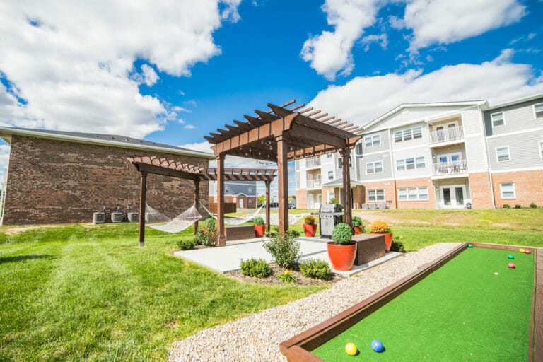 Bocce ball court and pergola with apartments in background